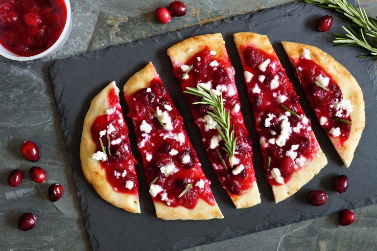 Holiday flatbread appetizer with cranberries and cheese, overhead scene