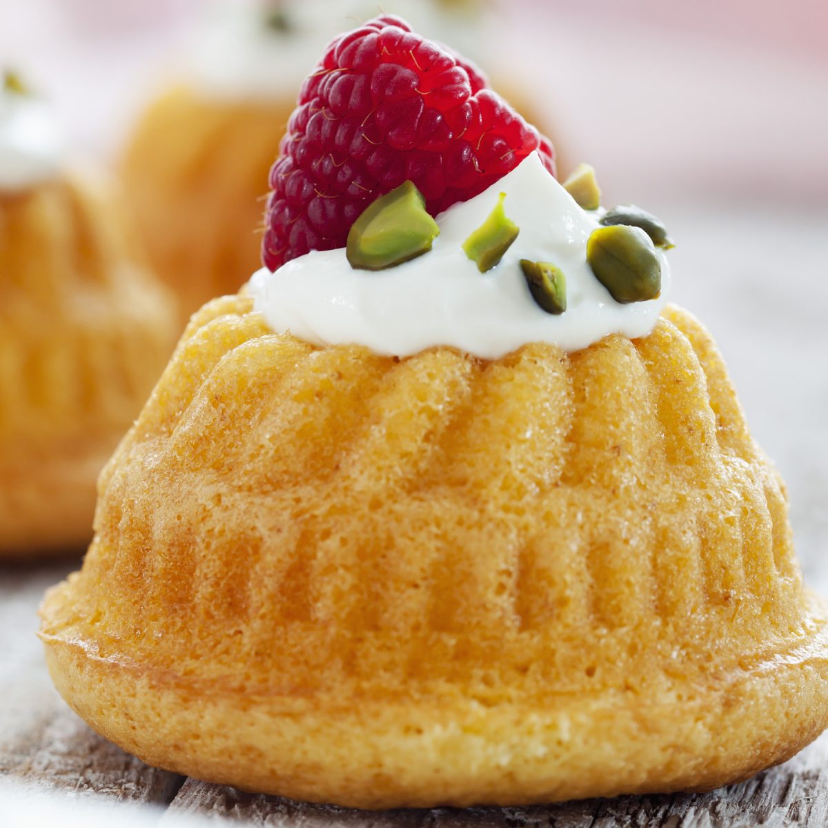 Molded muffins with ricotta cream, raspberries and pistachios - Photo by Tuned_In/Getty