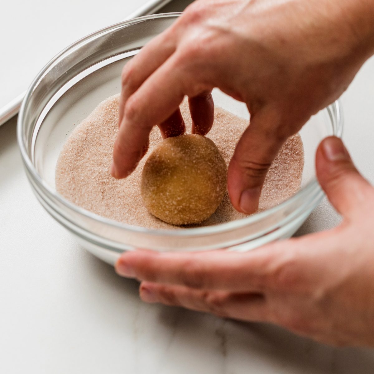 Rolling the dough balls in cinnamon sugar