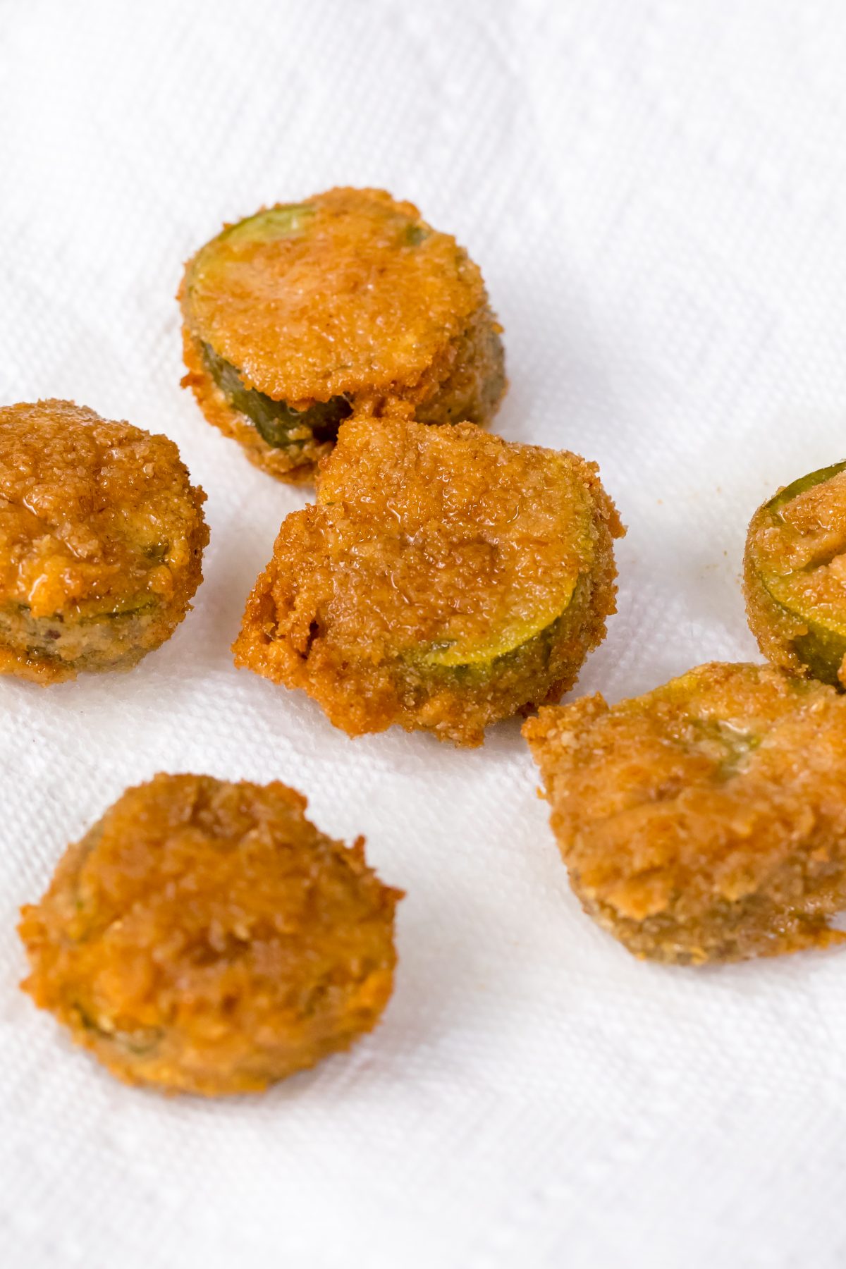 Place The best extra crispy fried pickles with Cajun dipping sauce on papertowels