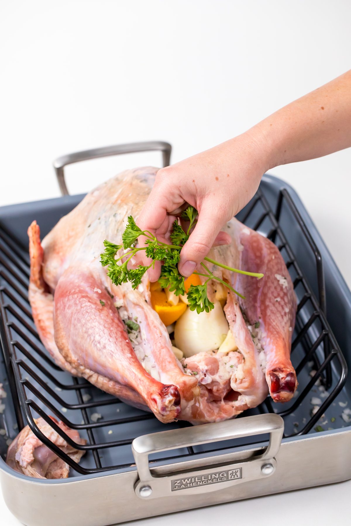 5D4B8979 - Bacon Wrapped Turkey - adding parsley into the inside cavity of the turkey