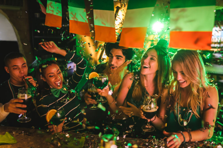 Friends partying with drinks and confetti on Saint Patrick's day