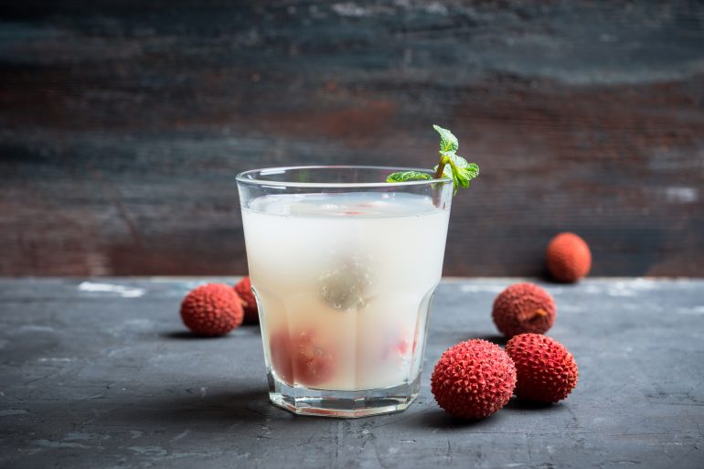 Old fahioned lychee cocktail on the rustic background