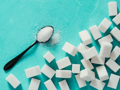 Top view of white sugar cubes on turquoise background